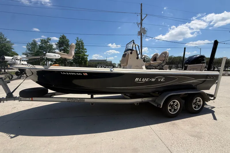 Slide: The Image of 2016 Blue Wave 2200 PureBay boat on trailer under clear blue sky. - 10