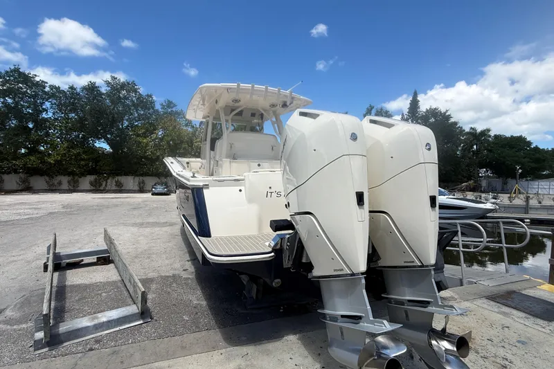Slide: The Image of 2025 Scout 330 LXF boat with dual engines, parked on a sunny day. - 3
