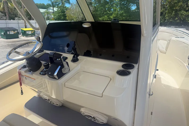Slide: The Image of 2025 Scout 330 LXF boat helm with steering wheel and control panel. - 6