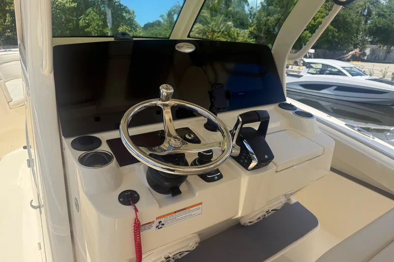Slide: The Image of 2025 Scout 330 LXF boat helm with steering wheel and controls. - 9
