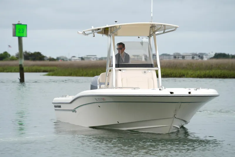 Slide: The Image of 2015 Grady-White 251 Coastal Explorer boat navigating calm waters near a green channel marker. - 15