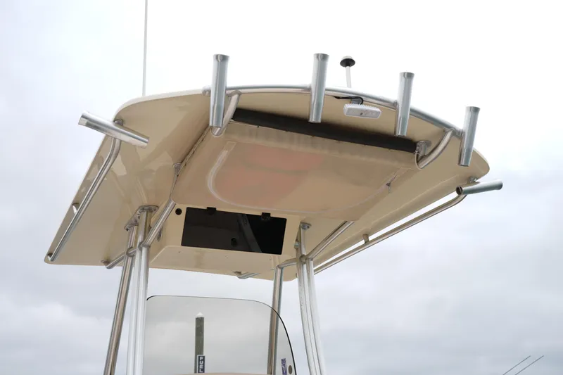 Slide: The Image of 2015 Grady-White 251 Coastal Explorer boat's T-top with rod holders against cloudy sky. - 22