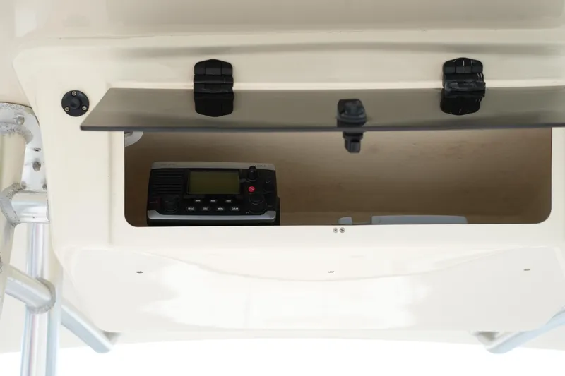 Slide: The Image of Storage compartment with radio equipment on a 2015 Grady-White 251 Coastal Explorer boat. - 30