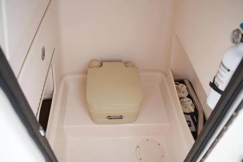 Slide: The Image of 2015 Grady-White 251 Coastal Explorer boat interior with portable toilet and fire extinguisher. - 31