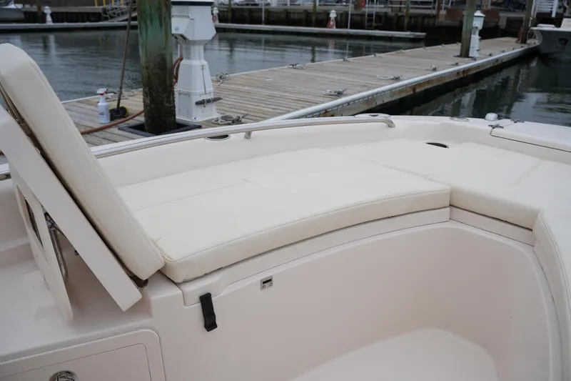 Slide: The Image of 2015 Grady-White 251 Coastal Explorer boat interior with cushioned seating at dock. - 36