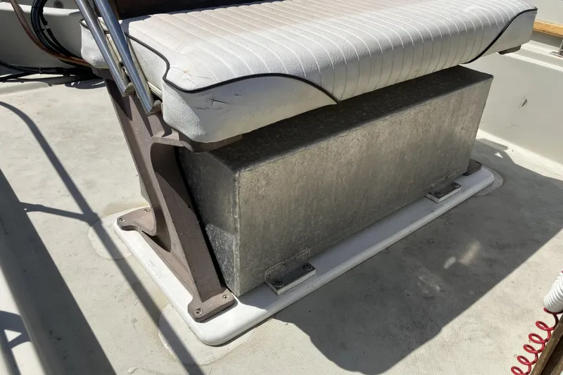 Slide: The Image of 1983 Boston Whaler 17 Montauk boat seat with storage compartment, featuring white cushioned seating. - 10