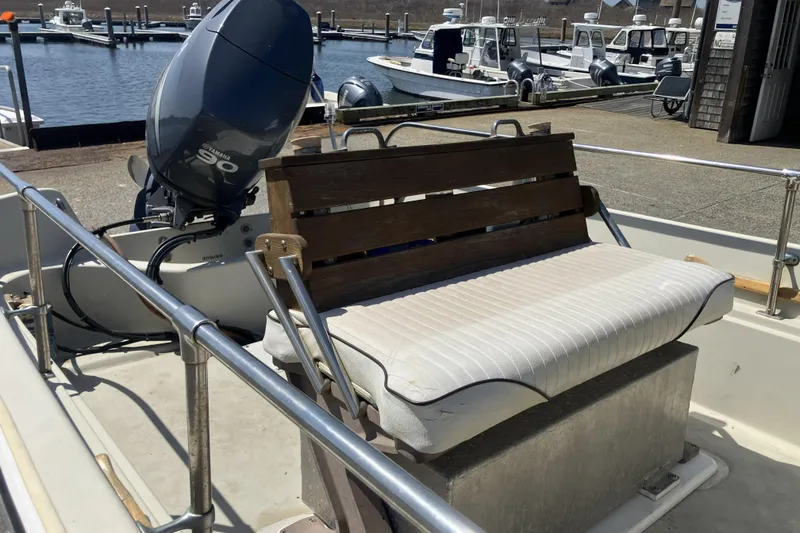 Slide: The Image of 1983 Boston Whaler 17 Montauk boat with Yamaha 90 engine at dockside. - 11