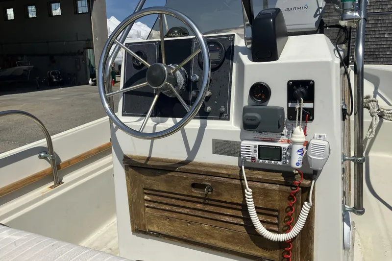 Slide: The Image of 1983 Boston Whaler 17 Montauk boat console with steering wheel and navigation equipment. - 12