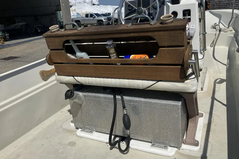 Slide: The Image of 1983 Boston Whaler 17 Montauk interior with wooden storage, steering wheel, and equipment. - 16