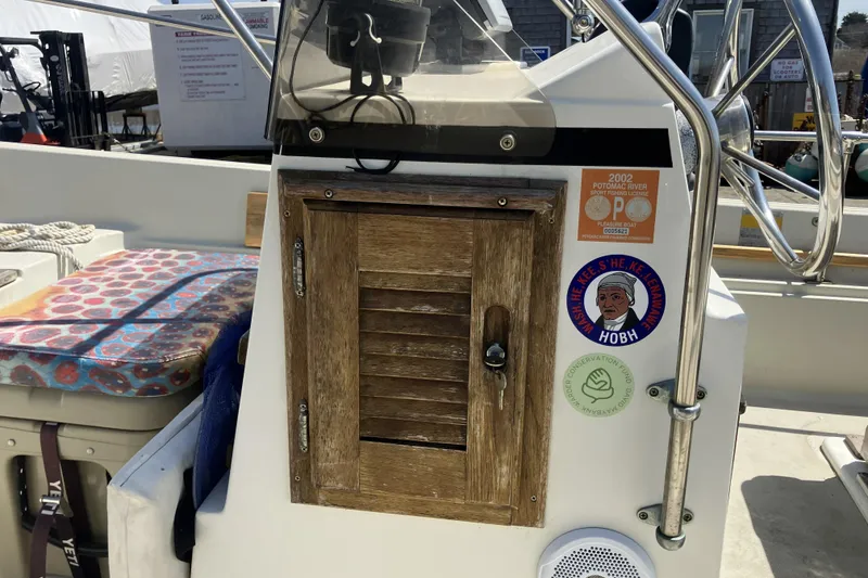 Slide: The Image of 1983 Boston Whaler 17 Montauk console with wooden cabinet and decorative stickers. - 19