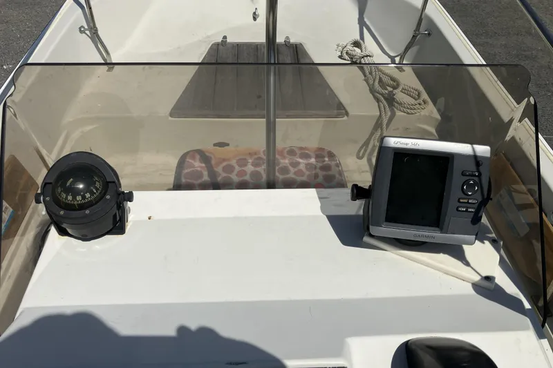Slide: The Image of 1983 Boston Whaler 17 Montauk dashboard with compass and Garmin GPS device. - 23