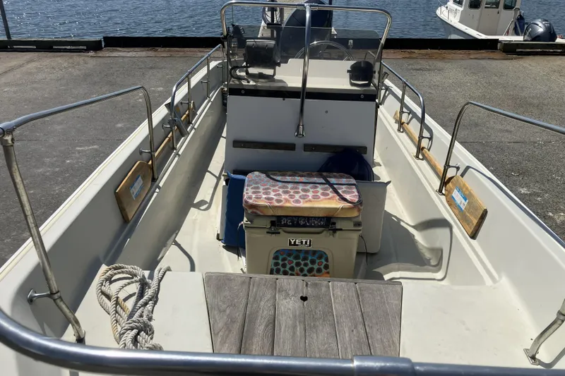 Slide: The Image of 1983 Boston Whaler 17 Montauk boat interior with Yeti cooler, docked by the water. - 6