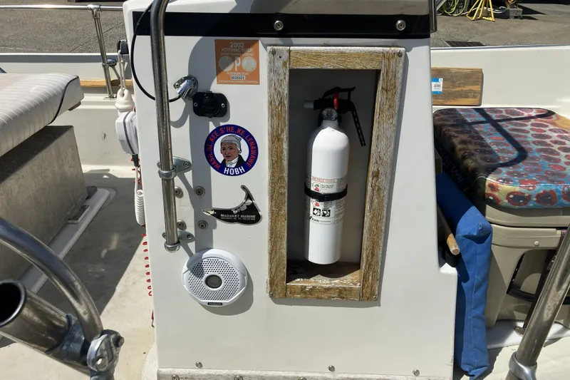 Slide: The Image of 1983 Boston Whaler 17 Montauk boat interior with fire extinguisher and safety equipment. - 8
