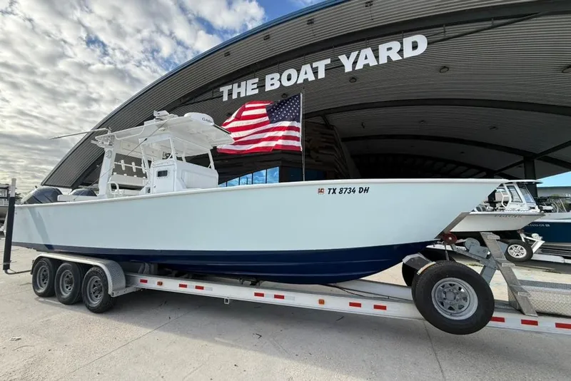 The Image of Custom 32 CC 2012 boat on trailer at The Boat Yard, American flag displayed. - 1