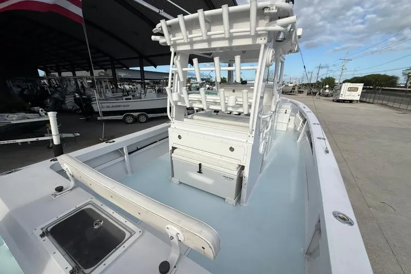 Slide: The Image of Custom 32 CC 2012 boat with center console, docked under a canopy on a sunny day. - 10