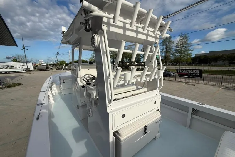 Slide: The Image of 2012 Custom 32 CC boat with rod holders and steering console, docked outdoors. - 13