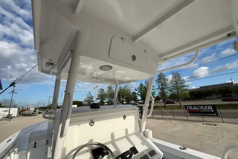 Slide: The Image of 2012 Custom 32 CC boat console with steering wheel, outdoor setting, and blue sky. - 15
