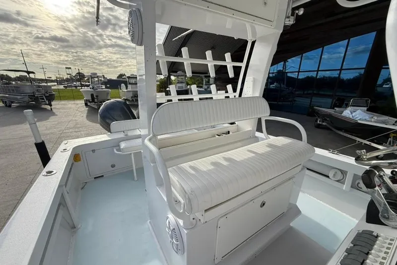 Slide: The Image of 2012 Custom 32 CC boat interior with white seating and storage, docked outdoors. - 18