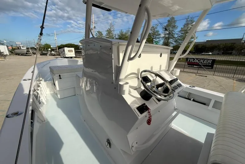 Slide: The Image of 2012 Custom 32 CC boat cockpit with steering wheel and console, parked outdoors. - 21