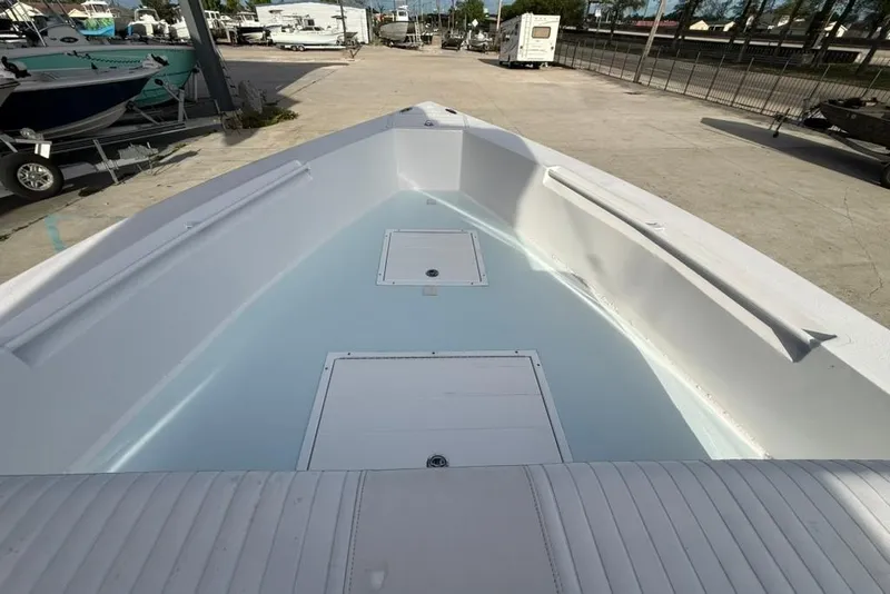 Slide: The Image of 2012 Custom 32 CC boat interior with storage compartments, parked in a marina. - 24