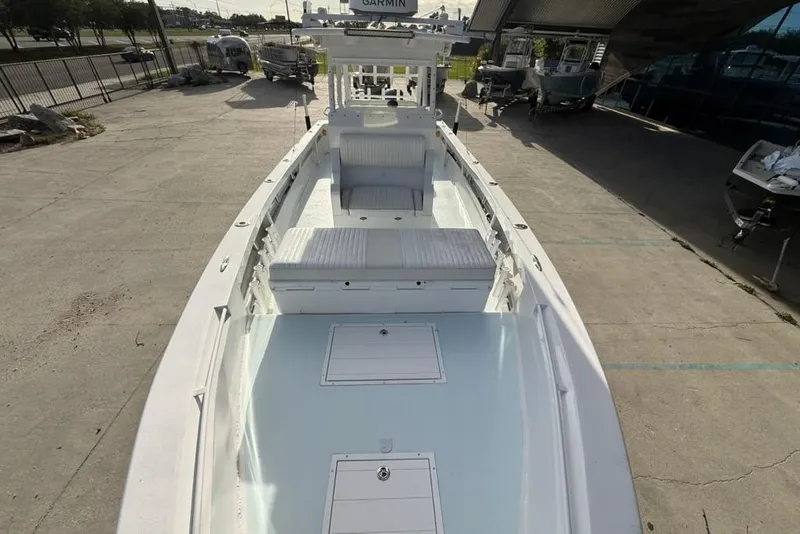 Slide: The Image of 2012 Custom 32 CC boat with spacious deck and seating, parked outdoors. - 25