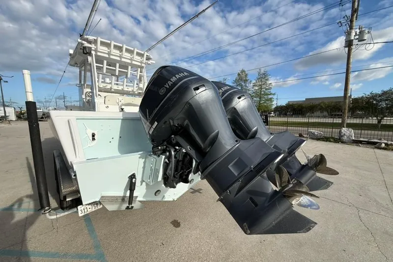 Slide: The Image of Twin Yamaha outboard motors on a 2012 Custom 32 CC boat, parked outdoors. - 3
