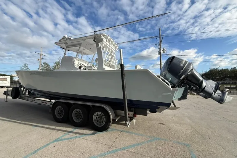 Slide: The Image of Custom 32 CC 2012 boat on trailer with Yamaha outboard motor under blue sky. - 4
