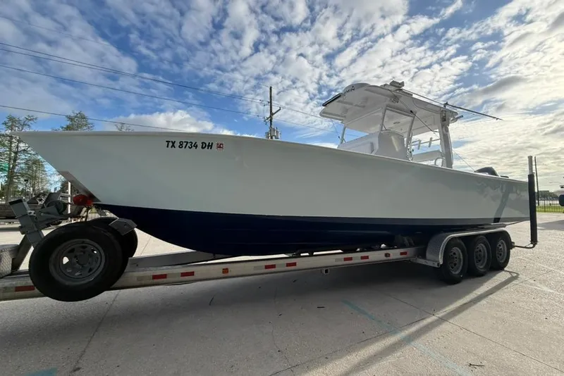 Slide: The Image of 2012 Custom 32 CC boat on trailer under a partly cloudy sky. - 5