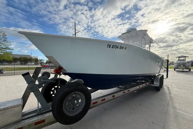 Slide: The Image of Custom 32 CC boat on trailer, 2012 model, parked outdoors under cloudy sky. - 6