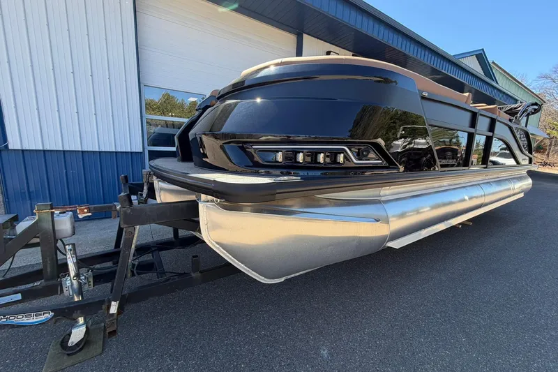 Slide: The Image of 2026 Harris Grand Mariner 250 SL pontoon boat on trailer, parked outside a building. - 7