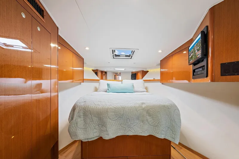 Slide: The Image of Luxurious cabin interior of a 1998 Viking 55 Convertible yacht with wood paneling and cozy bedding. - 10