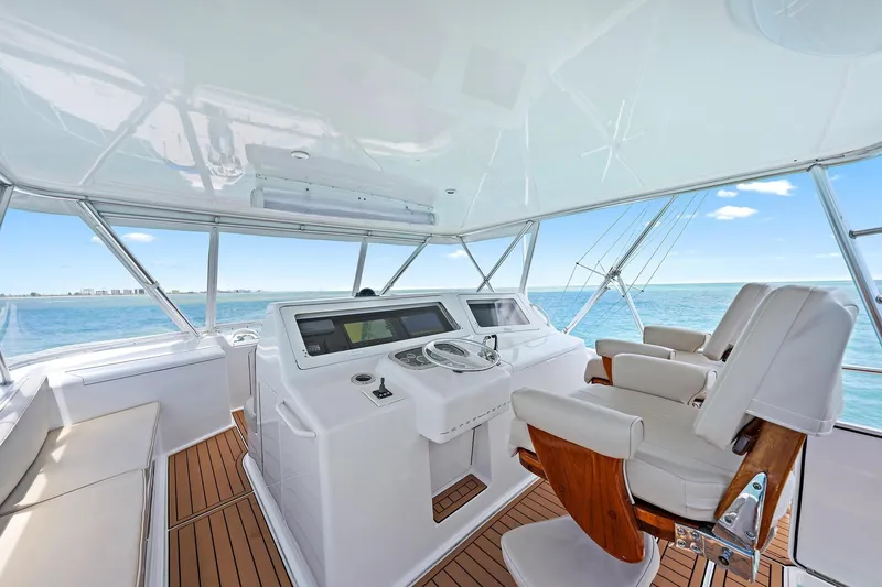 Slide: The Image of Luxurious Viking 55 Convertible yacht helm with ocean view, featuring modern controls and seating. - 11