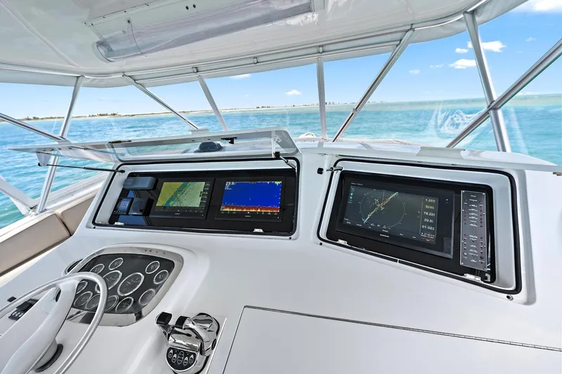 Slide: The Image of Viking 55 Convertible yacht helm with advanced navigation displays, steering wheel, and ocean view. - 12