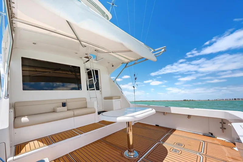 Slide: The Image of Luxury Viking 55 Convertible yacht deck with seating, table, and ocean view. - 14
