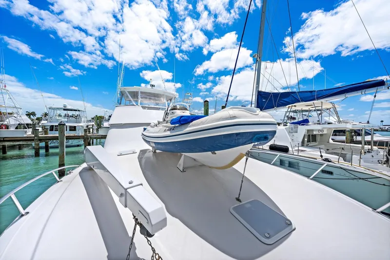 Slide: The Image of Luxury Viking 55 Convertible yacht docked, featuring a small boat on deck under a bright blue sky. - 17