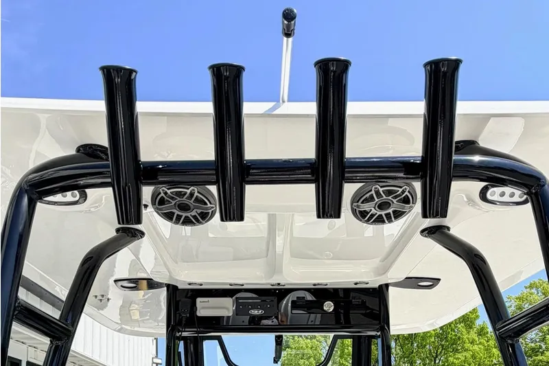 Slide: The Image of 2026 Sea Hunt Ultra 285 Coffin Box boat with rod holders and speakers under a clear blue sky. - 6