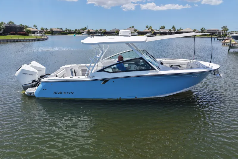 Slide: The Image of 2023 Blackfin 272 DC boat on calm water, featuring sleek design and Mercury engine. - 11