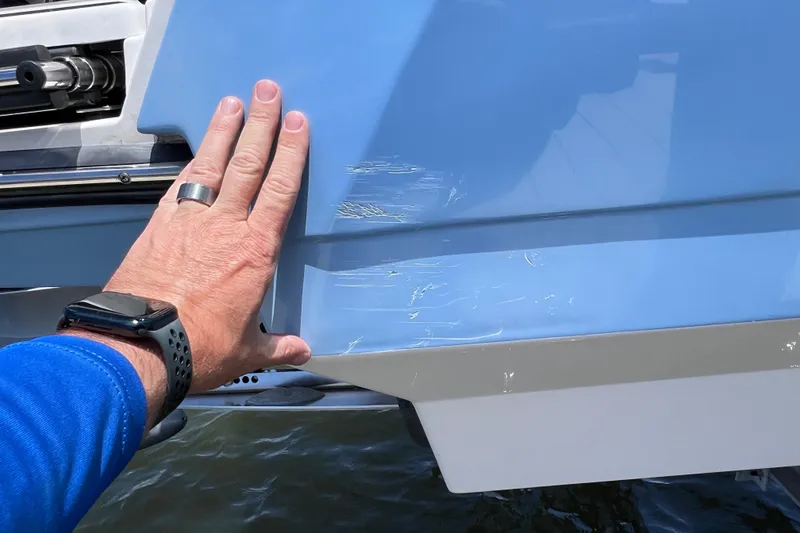 Slide: The Image of Hand inspecting scratches on 2023 Blackfin 272 DC boat hull. - 118