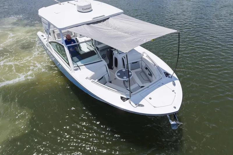 Slide: The Image of 2023 Blackfin 272 DC boat cruising on water with canopy extended. - 12