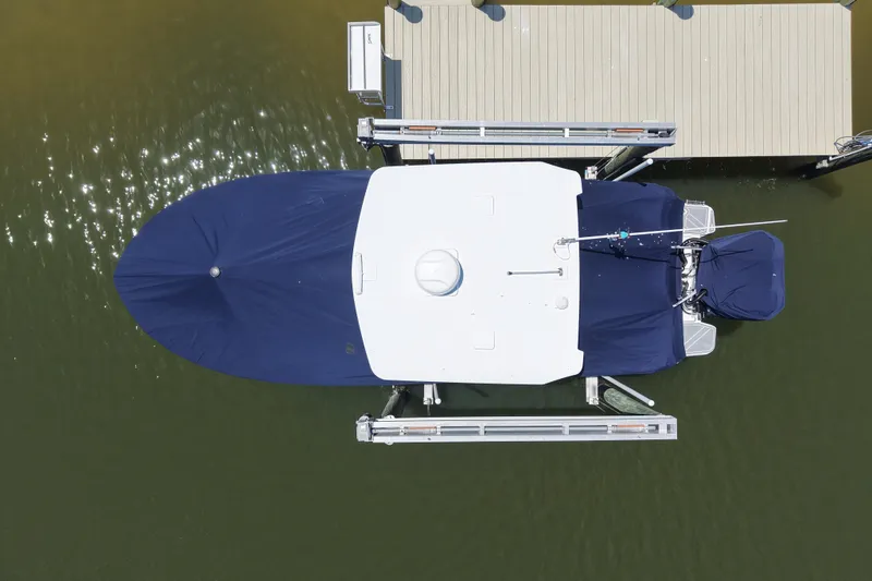 Slide: The Image of Aerial view of a covered 2023 Blackfin 272 DC boat docked at a pier. - 16