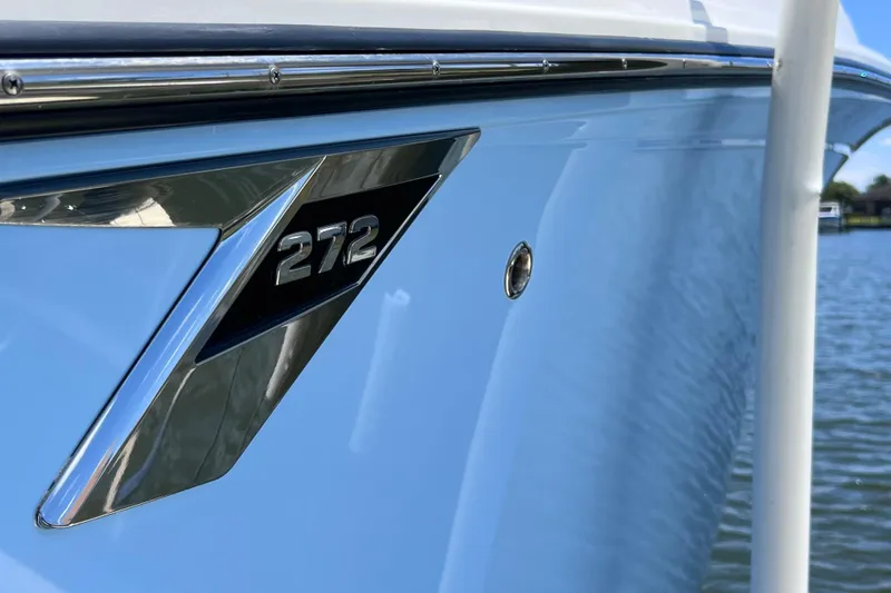 Slide: The Image of Close-up of 2023 Blackfin 272 DC boat emblem on sleek blue hull. - 20
