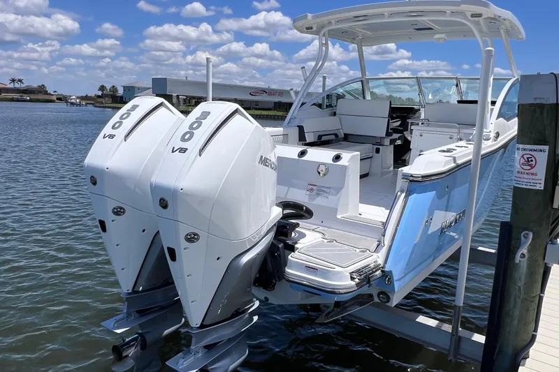 Slide: The Image of 2023 Blackfin 272 DC boat with twin Mercury 300 V8 engines docked by the water. - 22