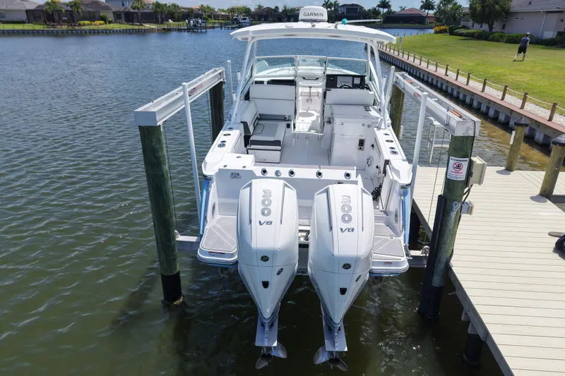 Slide: The Image of 2023 Blackfin 272 DC boat docked with twin 300 V8 engines, viewed from the rear. - 3