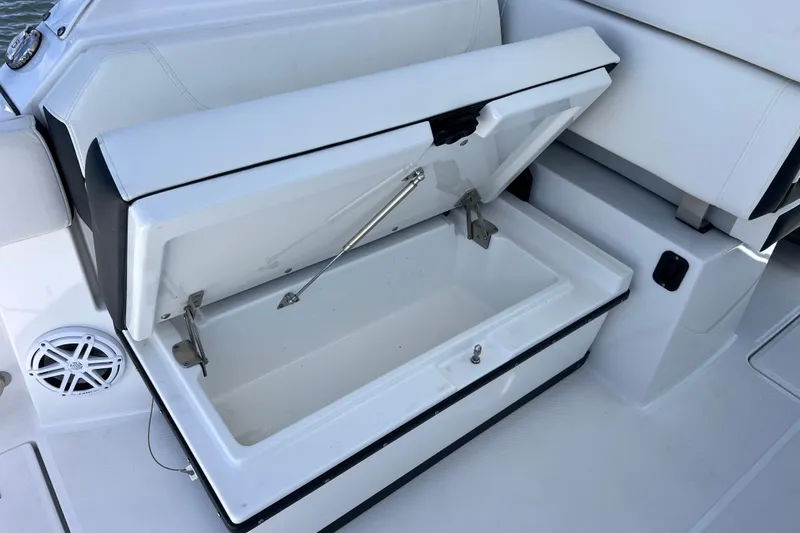 Slide: The Image of Open storage compartment on 2023 Blackfin 272 DC boat, featuring sleek white interior design. - 44