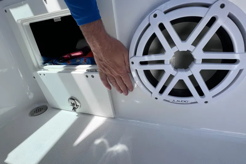 Slide: The Image of Hand near JL Audio speaker on 2023 Blackfin 272 DC boat interior. - 51