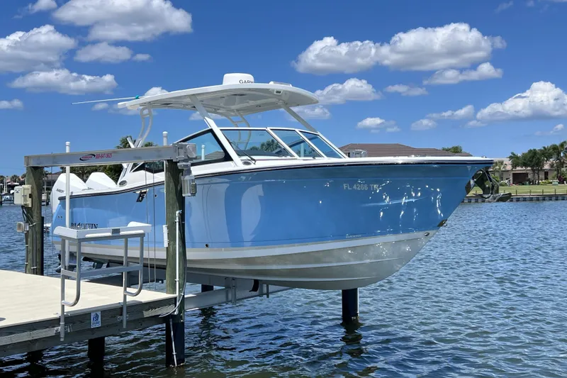 Slide: The Image of 2023 Blackfin 272 DC boat docked on a sunny day with blue skies. - 6