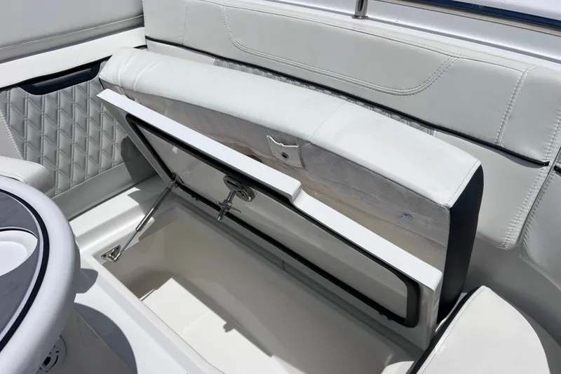 Slide: The Image of 2023 Blackfin 272 DC boat seat storage compartment, open with white upholstery. - 64