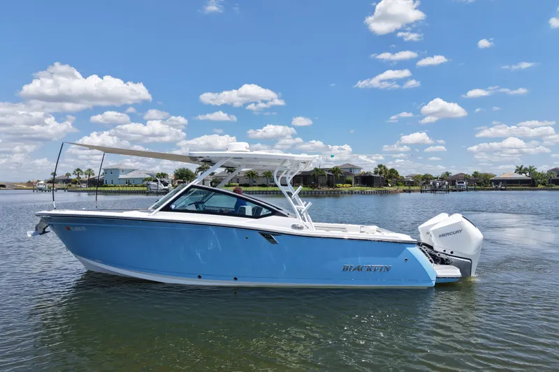 Slide: The Image of 2023 Blackfin 272 DC boat on a sunny lake with blue skies and clouds. - 7