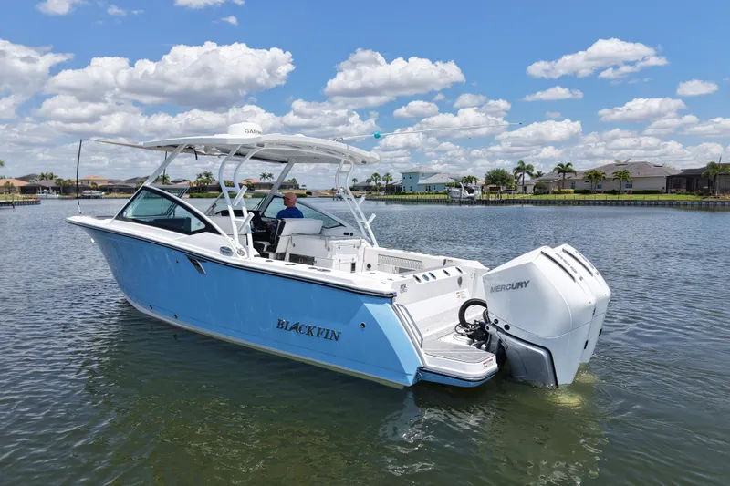 Slide: The Image of 2023 Blackfin 272 DC boat on calm water under a blue sky with clouds. - 8