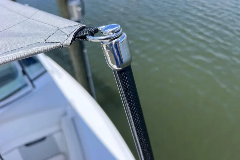 Slide: The Image of Close-up of a 2023 Blackfin 272 DC boat canopy attachment over water. - 81
